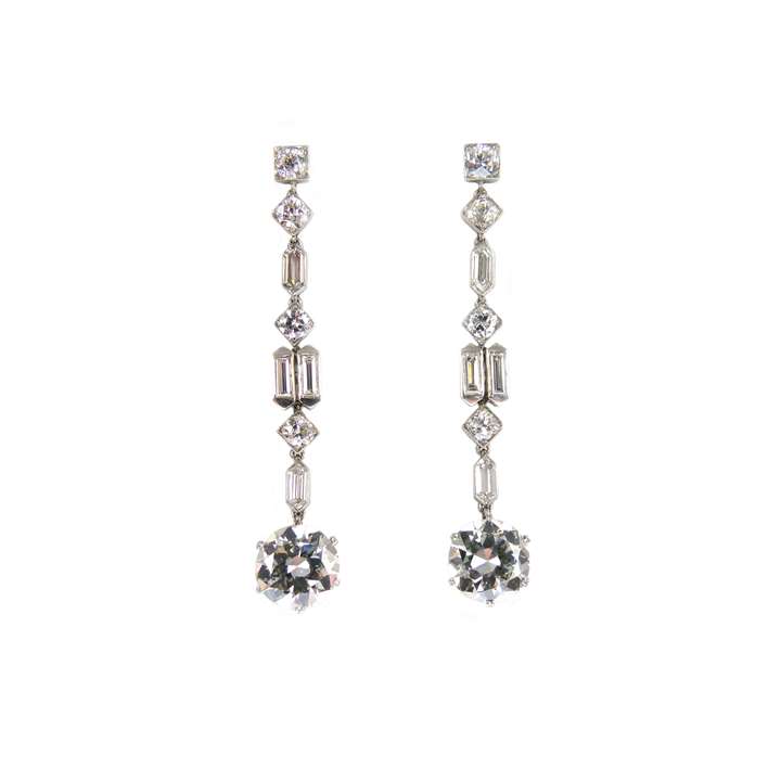 Pair of diamond pendant earrings of geometric design, each hung with a principal round brilliant cut diamond